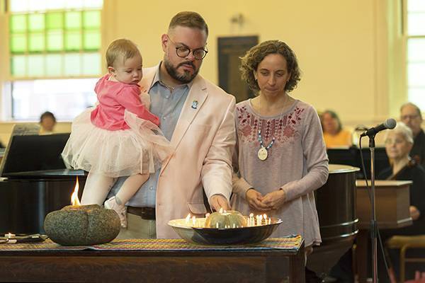 Members of First Parish Unitarian Universalist Church light candles